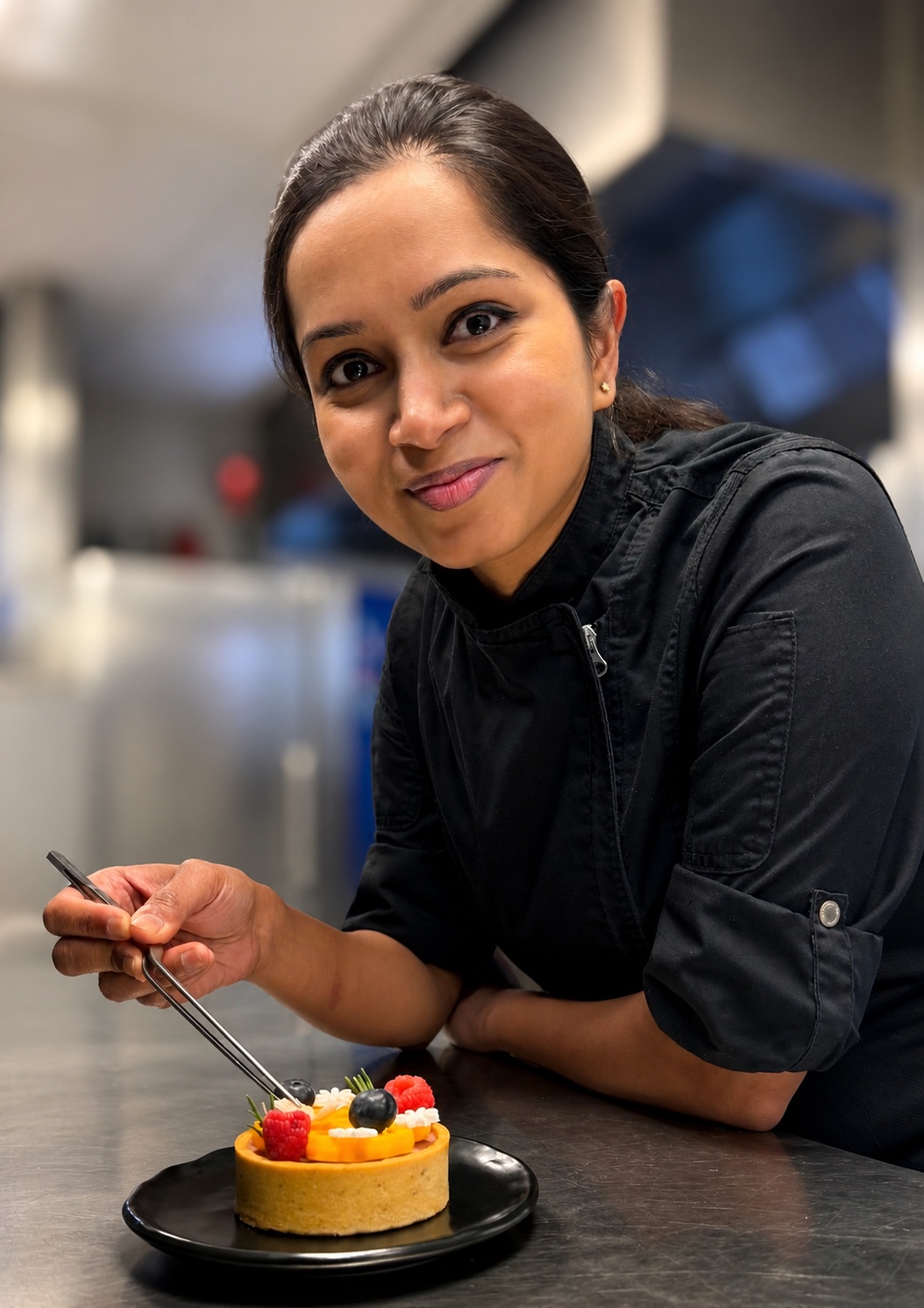 The chef of AIKA Patisserie finishing a fresh fruit tart